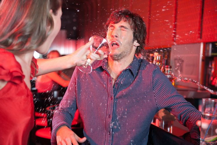 Woman in nightclub throwing beverage in man's face